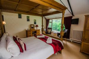 a bedroom with a large bed and a large window at Royal Lodge in Symonds Yat