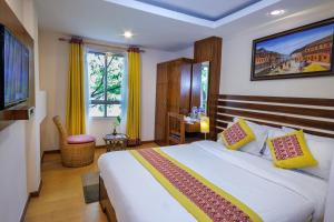 ein Schlafzimmer mit einem großen Bett und einem Fernseher in der Unterkunft Hotel Central Prime in Kathmandu + 46 Fotos