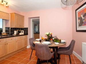 a kitchen with a wooden table with chairs and a dining room at Frenchgate Cottage in Richmond