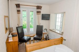 a bedroom with two chairs and a desk and a bed at Royal Lodge in Symonds Yat