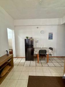 a living room with a table and a refrigerator at Confort total, cerca de todo in Asunción