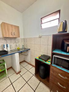 a kitchen with a sink and a counter with a microwave at Confort total, cerca de todo in Asunción +8 photos