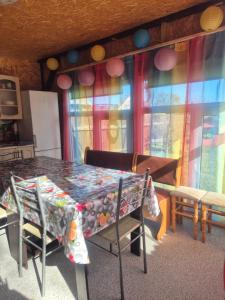 a room with a table and chairs and windows at Pik-Nik Sētiņa in Ventspils +20 photos