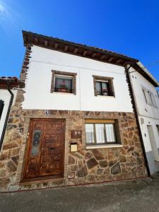 a stone house with two windows and a door at MyG-BarriAlto in Cirueña