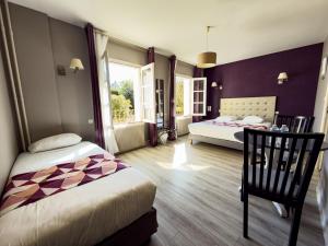a bedroom with two beds and a large window at Logis Hotel Restaurant des Voyageurs in Tarnac