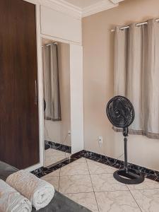 a room with a fan in the corner of a room at Pousada Acessus Clássico - Cozinha e Lavanderia in Anápolis
