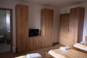 a bedroom with two beds and a flat screen tv at Penzion nad Halou in Lázně Kynžvart