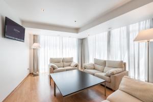 a living room with two chairs and a table at Dorma Puerta de San Pedro in Lugo