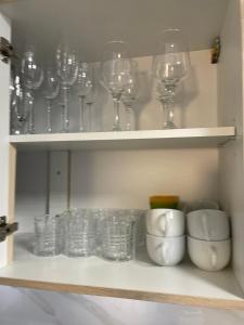 a shelf with wine glasses and cups on it at Ferienwohnung Nelli in Sankt Englmar +24 photos