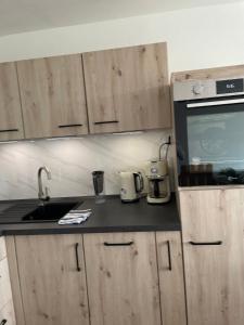 a kitchen with wooden cabinets and a sink and a microwave at Ferienwohnung Nelli in Sankt Englmar
