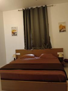 a bedroom with a large bed with a window at sea stay inn in Mahabalipuram +10 photos