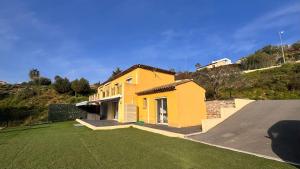 a yellow house on a hill with a yard at Villa Horizon in Nice