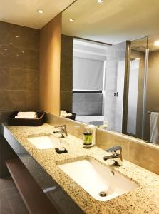 Un baño con dos lavabos y un espejo grande. en Inn by the Village, en Taitung 38 fotos más