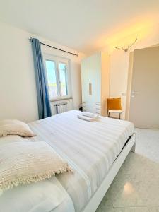 a large white bed in a room with a window at Sunrise apartament in Monterosso al Mare