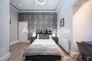 a bedroom with a bed with alove barber sign on the wall at Hackney Suites - En-suite rooms & amenities in London