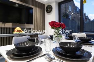 a table with black plates and red roses on it at Hackney Suites - En-suite rooms & amenities in London