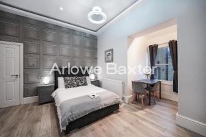 a bedroom with a bed and a desk at Hackney Suites - En-suite rooms & amenities in London +27 photos