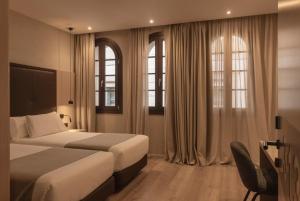 a hotel room with two beds and two windows at Gran Hotel Barcino 4 Sup in Barcelona +35 photos
