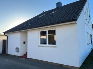 a white house with a black roof at Work & Stay - Monteurzimmer - FeWo am NOK in Rendsburg +5 photos