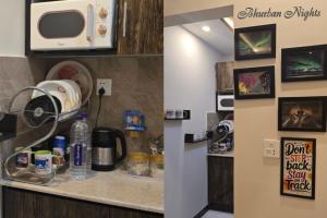 a kitchen with a counter top with a microwave at Bhurban Nights - Glass Bed Murree Hills View - Lift - 15 Minutes from Murree & Mallroad in Murree
