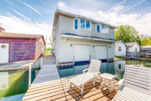 a house on a dock with two chairs on the water at The Boat House w/ Dock: Enjoy Lake Life! in North Webster