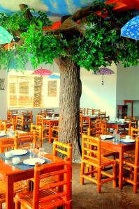 ein Restaurant mit Tischen und ein Baum mit Sonnenschirmen in der Unterkunft Oasis Resort and Spa in Boracay