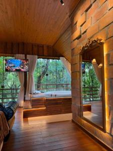 a room with a large stone wall with a large window at Chalé Belluno in Casca