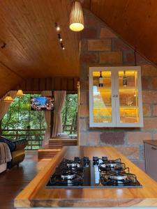a kitchen with a stove top in a room at Chalé Belluno in Casca