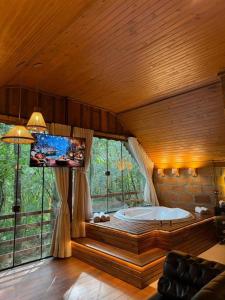 a large tub in a room with a large window at Chalé Belluno in Casca