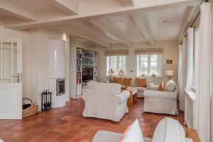 a living room with white furniture and a fireplace at Lunhues Lucia in Dunsum