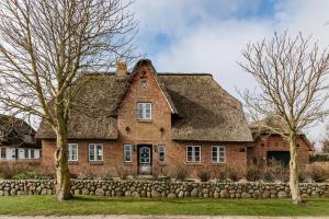an old brick house with a thatched roof at Lunhues Lucia in Dunsum