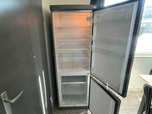 an empty refrigerator with its door open in a kitchen at Veluwse Vlucht in Putten +21 photos