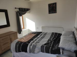 a bedroom with a bed with a blanket on it at Castlehill, Sanday in Sanday