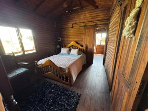 a bedroom with a bed in a wooden cabin at Cabañas - Raíces de la Sierra in Balcarce