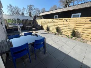 a patio with a table and chairs and a fence at Veluwse Vlucht in Putten