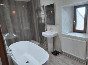 a bathroom with a sink and a toilet and a tub and a sink at Castlehill, Sanday in Sanday