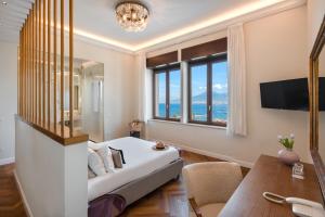 a bedroom with a bed and a desk and a window at Experience Boutique Hotel - Villa Cimmino in Castellammare di Stabia