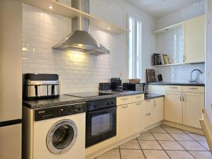 a kitchen with a washer and dryer in it at L'Authentique Centre-Ville - Perpignan in Perpignan