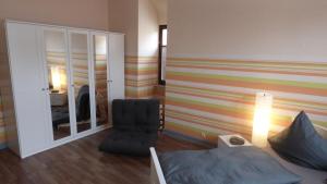 a bedroom with a striped accent wall and a chair at Ferienwohnung Baars in Bad Sachsa