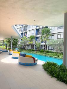 a hotel lobby with a pool and furniture and a building at Dcondo Reef kathu Patong in Kathu