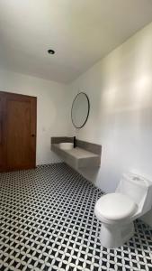 a bathroom with a toilet and a sink and a mirror at Casa Olivos in Ciudad Vieja