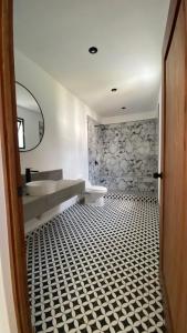a bathroom with a sink and a black and white tiled floor at Casa Olivos in Ciudad Vieja