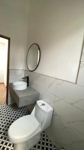 a white bathroom with a toilet and a mirror at Casa Olivos in Ciudad Vieja