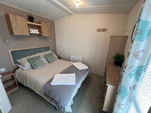 a small bedroom with a bed and a window at Celebration by the sea in Redcar
