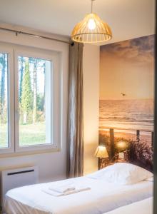 a bedroom with a large window and a bed at Cottages Du Domaine Du Marquenterre in Saint-Quentin-en-Tourmont