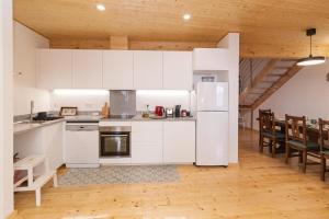 a kitchen with white cabinets and a table and chairs at Apartamento espaçoso em Lagos – ideal para grupos in Lagos