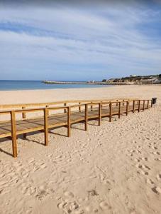 a wooden boardwalk on a beach near the water at Apartamento espaçoso em Lagos – ideal para grupos in Lagos