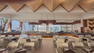 バンブリにあるBamburi Beach Hotelのテーブルと椅子のあるダイニングルームとレストラン
