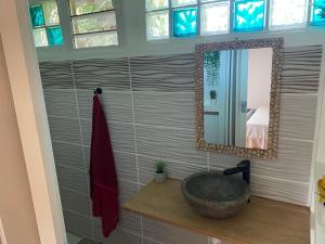a bathroom with a sink and a mirror at Logement entier, Bungalow ou T2 in Sainte-Rose +23 photos
