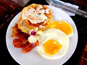 a plate of breakfast food with eggs and bacon at Oasis Resort and Spa in Boracay